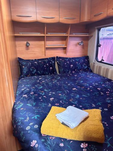 uma cama na parte de trás de uma carrinha com um cobertor em Kiwi Caravan Experience em Motueka