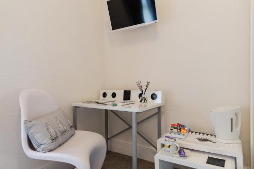 a room with a white desk and a chair and a table at The Bell Lodge in Sandown