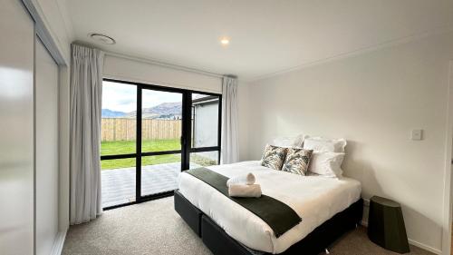 a bedroom with a bed and a large window at Remarkable Stay with Mountain View’s in Frankton Wharf