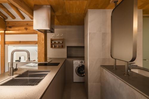 a kitchen with a sink and a washing machine at Luxury hanok with private bathtub - SN06 in Seoul
