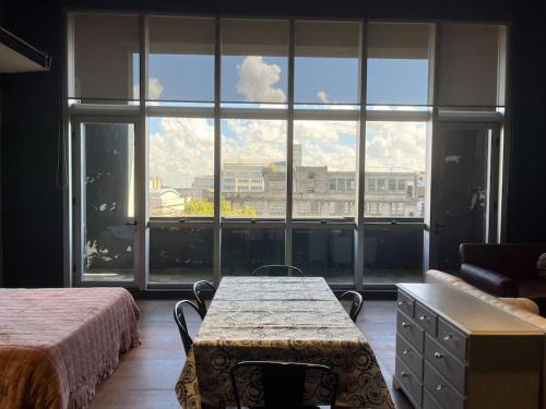 una camera da letto con tavolo e ampia finestra di Loft luminoso en Capital Federal a Buenos Aires