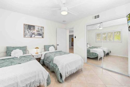 a bedroom with two beds and a sliding glass door at Modern spacious house with private pool and lake view in Fort Lauderdale