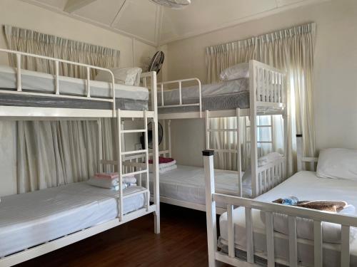 Ban SieoにあるAnna Hostel in Chaiyaphumの白い二段ベッド3組が備わる客室です。