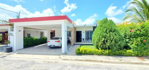a white car parked in front of a house at Pine Tree Entire House 2B Gated Com in Higuey