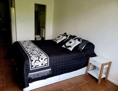 a bedroom with a bed with black and white pillows at Studio 109-comfortable, practical, great location in Brasilia