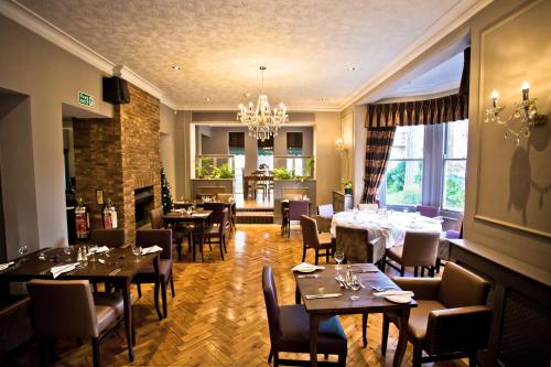 a restaurant with tables and chairs and a chandelier at Wards Hotel & Restaurant in Folkestone