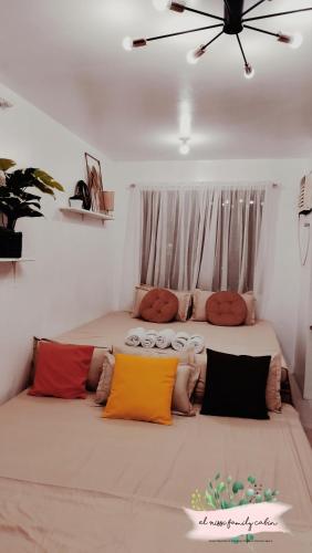 1 dormitorio con 2 camas y almohadas coloridas en El Nissi Family Cabin (Condo Beside Enchanted Kingdom), en Santa Rosa
