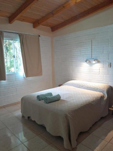 a bedroom with a white bed with two towels on it at La Casita de Irene in Puerto Rico