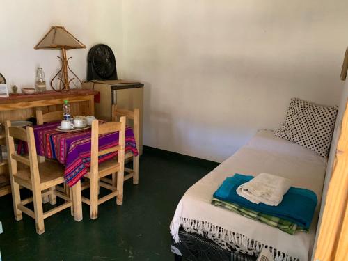 a room with a table and a bed and a desk at Cabaña La Apacheta Cachi Salta in Cachí