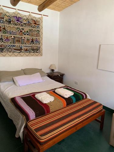 a bedroom with a bed with a blanket on it at Cabaña Apacheta Mi Campito Cachi Salta in Cachí