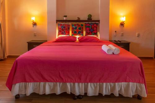 a bedroom with a large red bed with two white towels at Oasis Maya in Tuxtla Gutiérrez