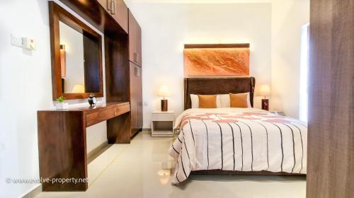 ein Schlafzimmer mit einem Bett, einem Waschbecken und einem Spiegel in der Unterkunft Luxurious 2 bedroom apartment - Ariyana Resort Apartments -Athurugiriya in Colombo