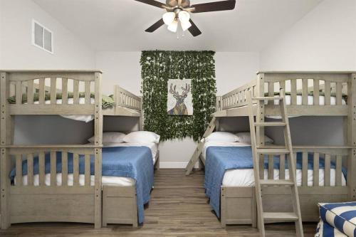 sypialnia z 2 łóżkami piętrowymi i wentylatorem sufitowym w obiekcie Gorgeous Lake Cabin Hot Tub w mieście Branson