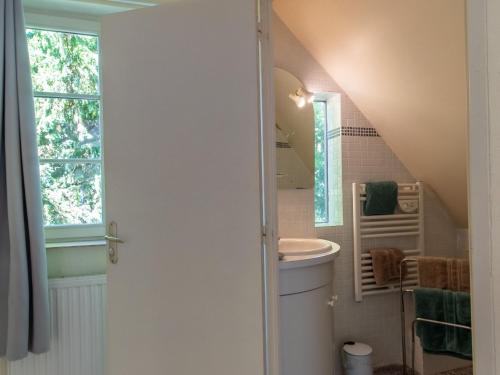 uma casa de banho com um lavatório, um WC e uma janela. em Gîte Denée, 2 pièces, 2 personnes - FR-1-622-37 em Denée