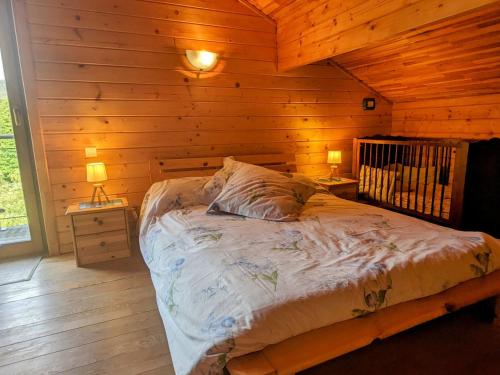 a bedroom with a bed in a wooden cabin at Chalet confortable avec cheminée à Taintrux - FR-1-589-222 in Taintrux