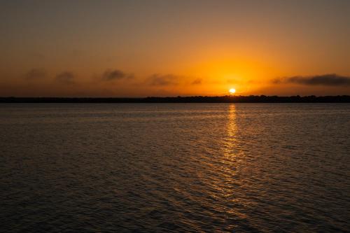 una puesta de sol sobre un gran cuerpo de agua en Hotel Boutique Aurea, en Bacalar