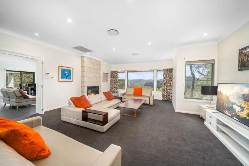 a living room with a couch and a tv at Cliffnest House in Katoomba