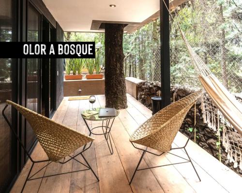 a porch with two chairs and a hammock at Fungi Tepoz Cabins in Tlacotenco
