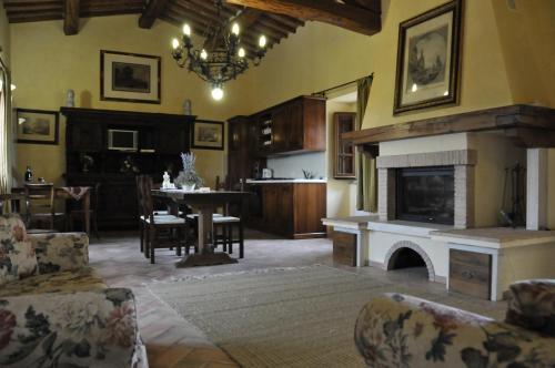 a living room with a fireplace and a dining room at Agriturismo Il Macchione in Pienza