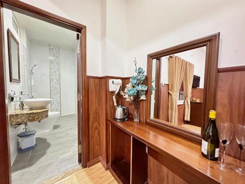 a bathroom with a wooden counter with a sink and a mirror at Nhat Minh Hotel - Etown and airport in Ho Chi Minh City