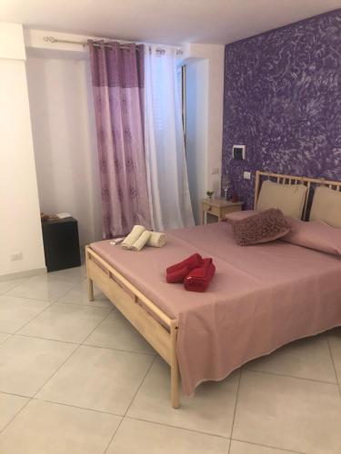Un dormitorio con una cama grande con almohadas rojas. en B&B Al Cavour, en Acireale