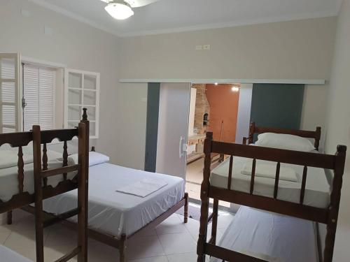 a bedroom with two bunk beds and a hallway at Casa com Piscina e churrasqueira/ mar casado in Guarujá
