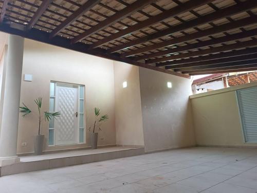 an empty room with two plants on the wall at Casa com Piscina e churrasqueira/ mar casado in Guarujá