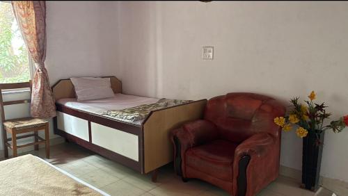 a small bedroom with a bed and a chair at Perfect Couple Bedroom in Panchgani