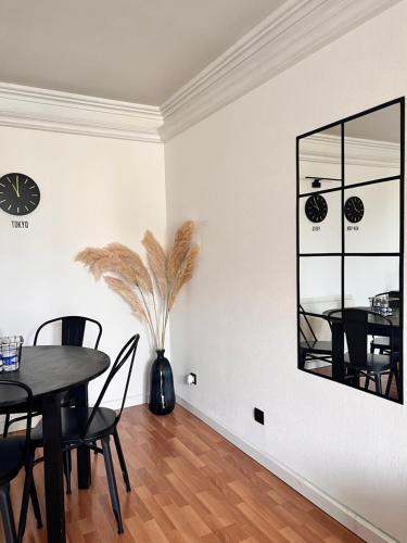 a dining room with a table and chairs and a clock on the wall at Le Joyau Caché Paris beautiful - Olympic games 2024 in Arnouville-lès-Gonesse