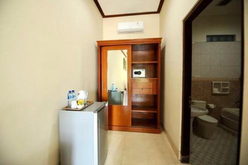 a small kitchen with a refrigerator and a bathroom at Tori Inn in Sanur