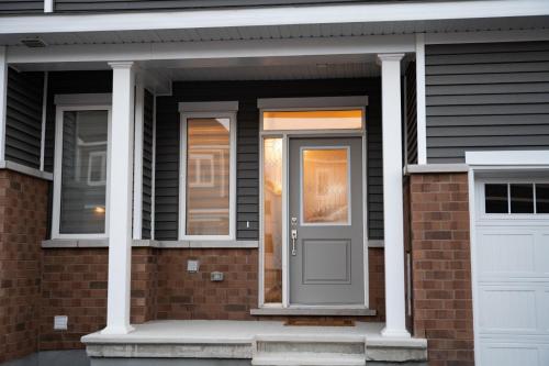 uma casa com uma porta cinzenta e uma janela em TN Homes em Ottawa