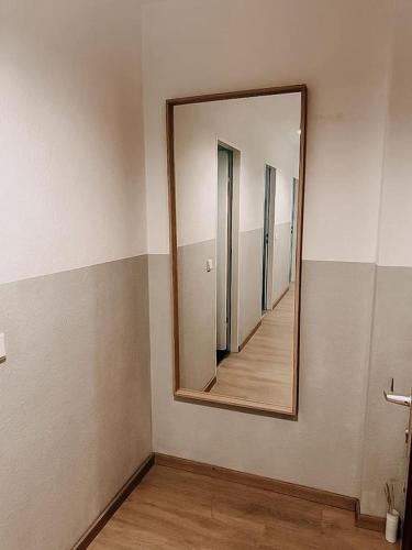 a mirror on a wall in a room with a hallway at Wohnen im 3 Ländereck! Essen, Mülheim, Oberhausen! BS2HL in Essen