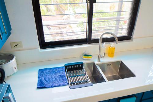 a kitchen counter with a sink and a window at LacambraHills Olongapo in Olongapo