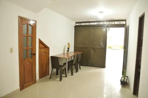 een eetkamer met een tafel en stoelen en een deur bij la casa del solo envigado in Envigado