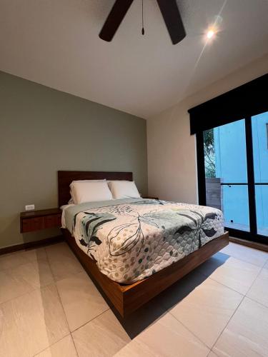 a bedroom with a bed and a large window at Mya Black Diamond 202 in Playa del Carmen