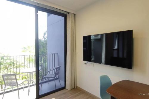 a living room with a television and a table and chairs at 普吉岛Laguna海滩豪华天际泳池公寓，奢华体验与休闲之选 in Phuket