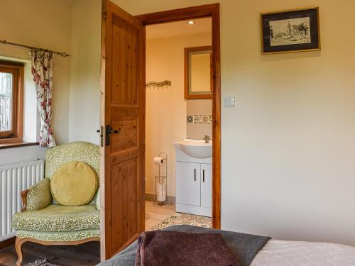 a bathroom with a chair and a sink in a room at The Bull Pen - 17320 in Compton