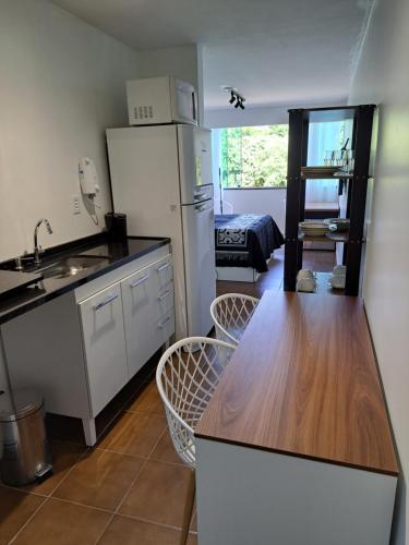 a kitchen with a refrigerator and a table and chairs at Studio 109-comfortable, practical, great location in Brasilia