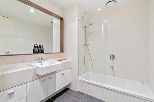 uma casa de banho branca com um lavatório e um chuveiro em Southbank Two Bedroom Apt - 2202 em Melbourne