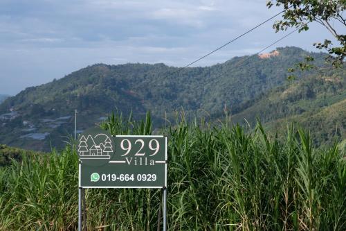 Kampong Kundassan的住宿－929 Villa, kundasang，山边的标志,山底下有山