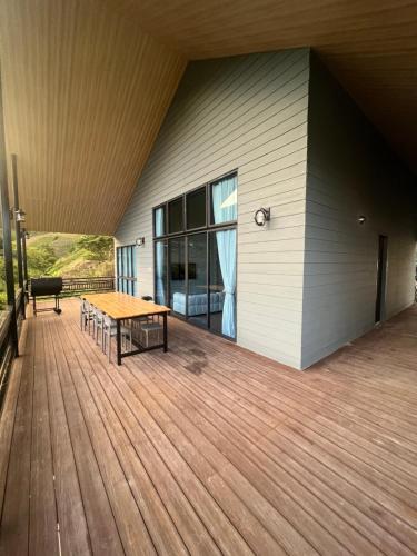 a wooden deck with a table on the side of a house at 929 Villa, kundasang in Kundasang