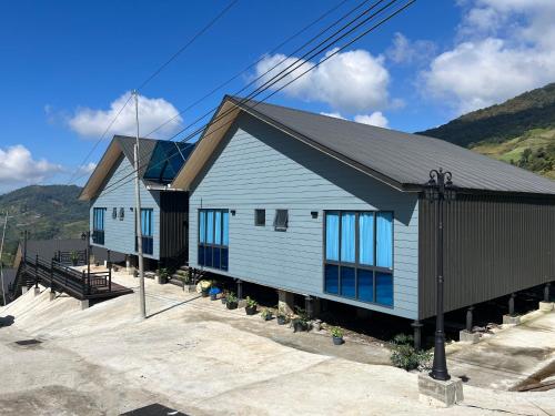 a blue building with windows and mountains in the background at 929 Villa, kundasang in Kundasang