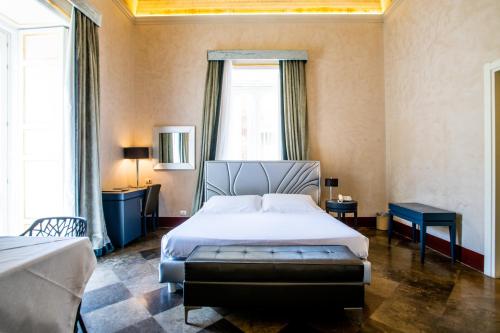 a bedroom with a bed and a large window at De Stefano Palace Luxury Hotel in Ragusa