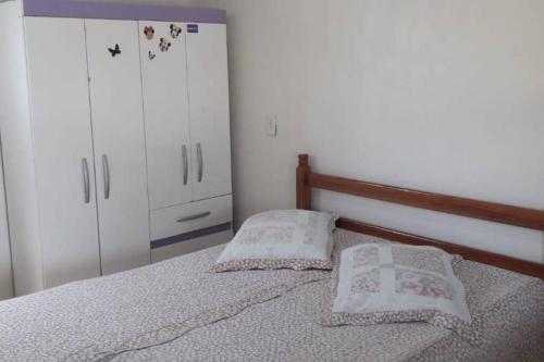 a bedroom with a bed with two pillows on it at Casa com Wi-fi, pertinho do Mar! in Matinhos
