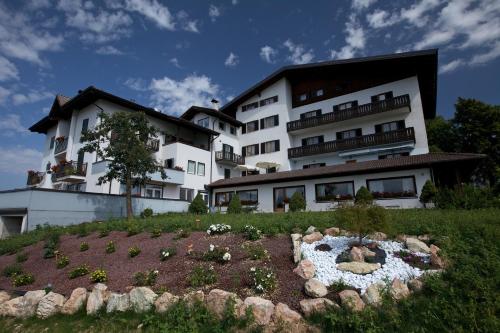 - un grand bâtiment blanc avec un jardin en face dans l'établissement Hotel Antica Torre, à Coredo