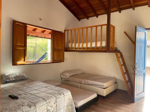 a bedroom with two bunk beds and a window at CABAÑA CAMPESTRE - San Gil in San Gil