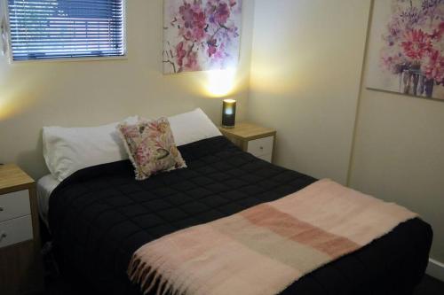 a bedroom with a bed with a black blanket at Very Close to Town- Mountain Views in Queenstown