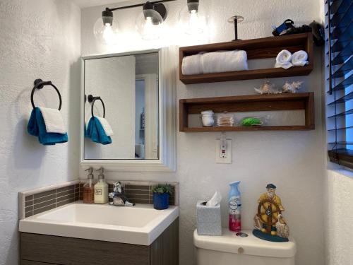 a bathroom with a sink and a mirror and a toilet at Condo by the Sea in Lincoln City