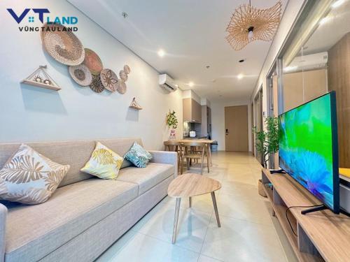 a living room with a couch and a flat screen tv at The Song Vung Tau Homestay - VTLand in Vung Tau