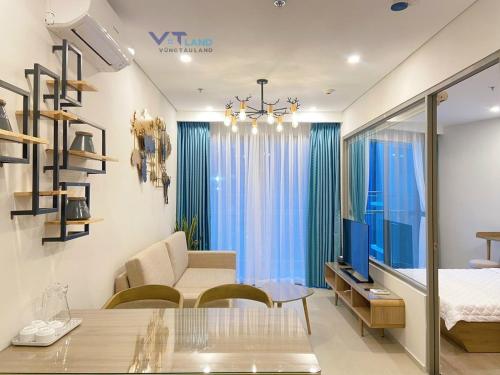 a living room with a couch and a tv in a room at The Song Vung Tau Homestay - VTLand in Vung Tau